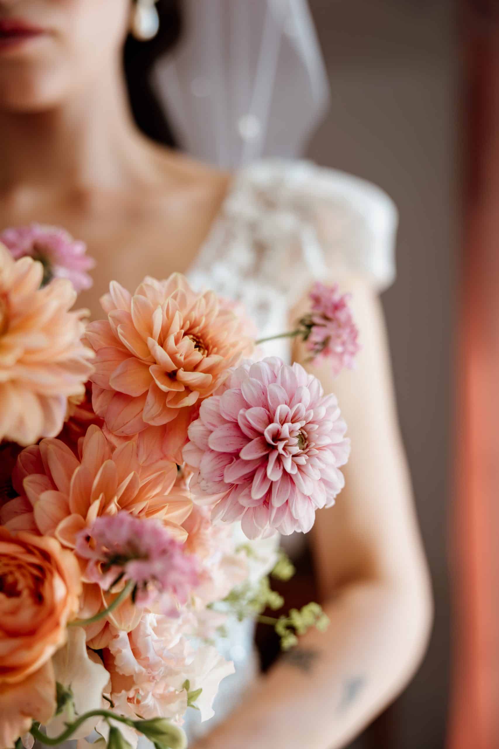 Mariée tenant un bouquet sauvage et coloré des Nanas